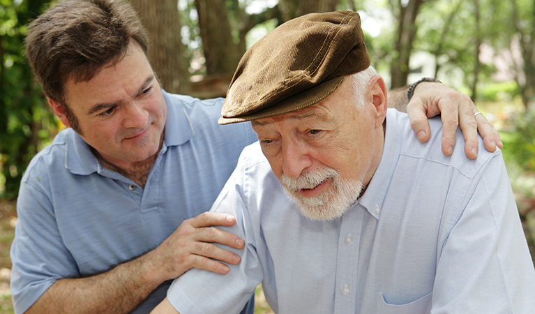 Senior man in failing health and his worried middle-aged son. Focus on Senior man.